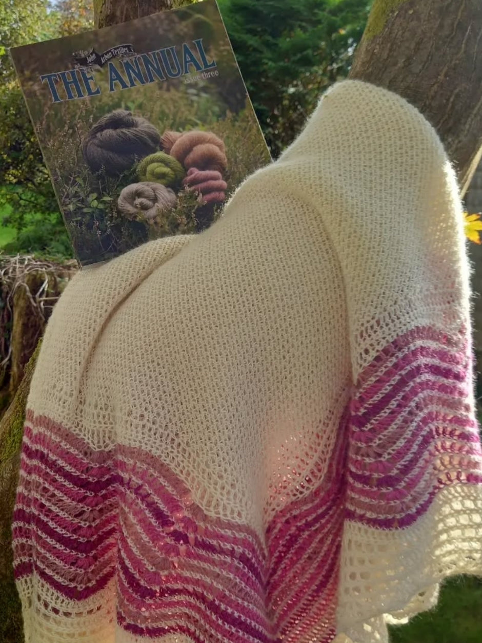 A cream and pink crocheted blanket with an heirloom lace feel.  