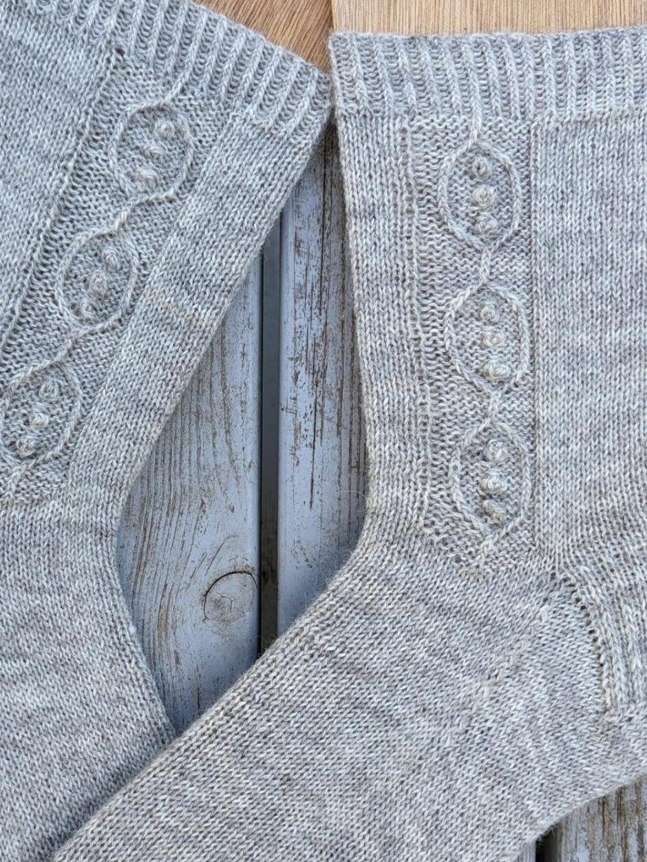 Light grey socks wiht a peapod design.