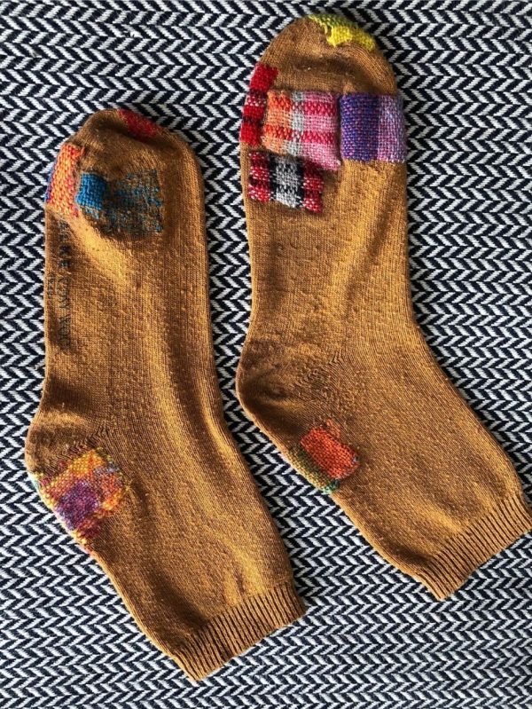 Socks darned with colourful threads