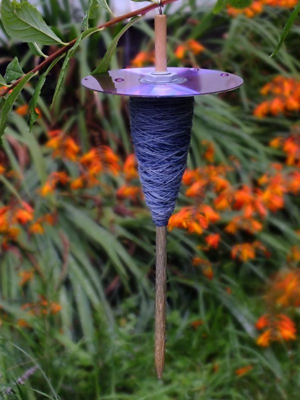 A CD drop spindle with purple yarn